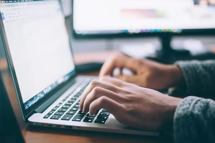 Frauenhände an einer Tastatur eines Laptops